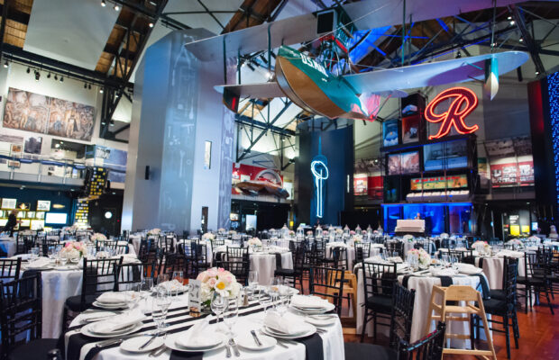 The Faye G. Allen Grand Atrium at MOHAI set up for an event with a farmhouse table. The Boeing B-1 hangs overhead. The Rainer 