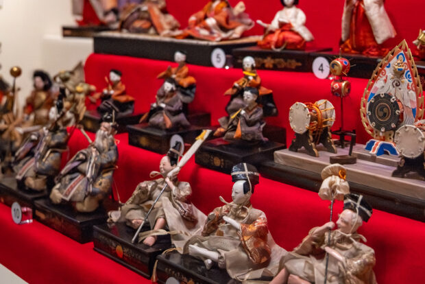 A collection of Japanese dolls displayed on red felt.