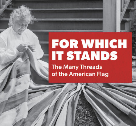 A woman sits while sewing the American Flag.